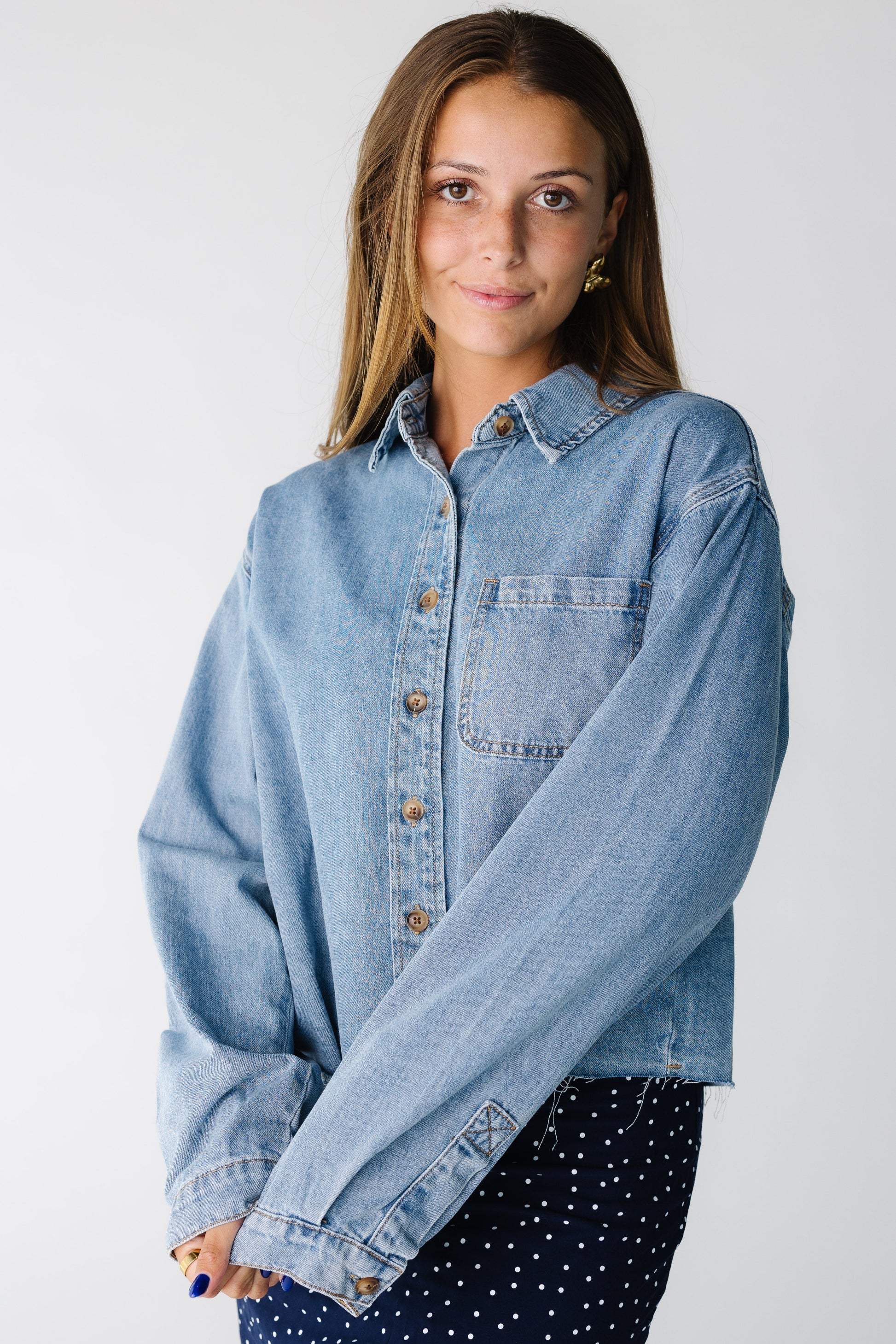 Woman wearing a long sleeve denim shirt with a single patch pocket