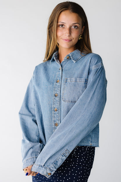 Woman wearing a long sleeve denim shirt with a single patch pocket