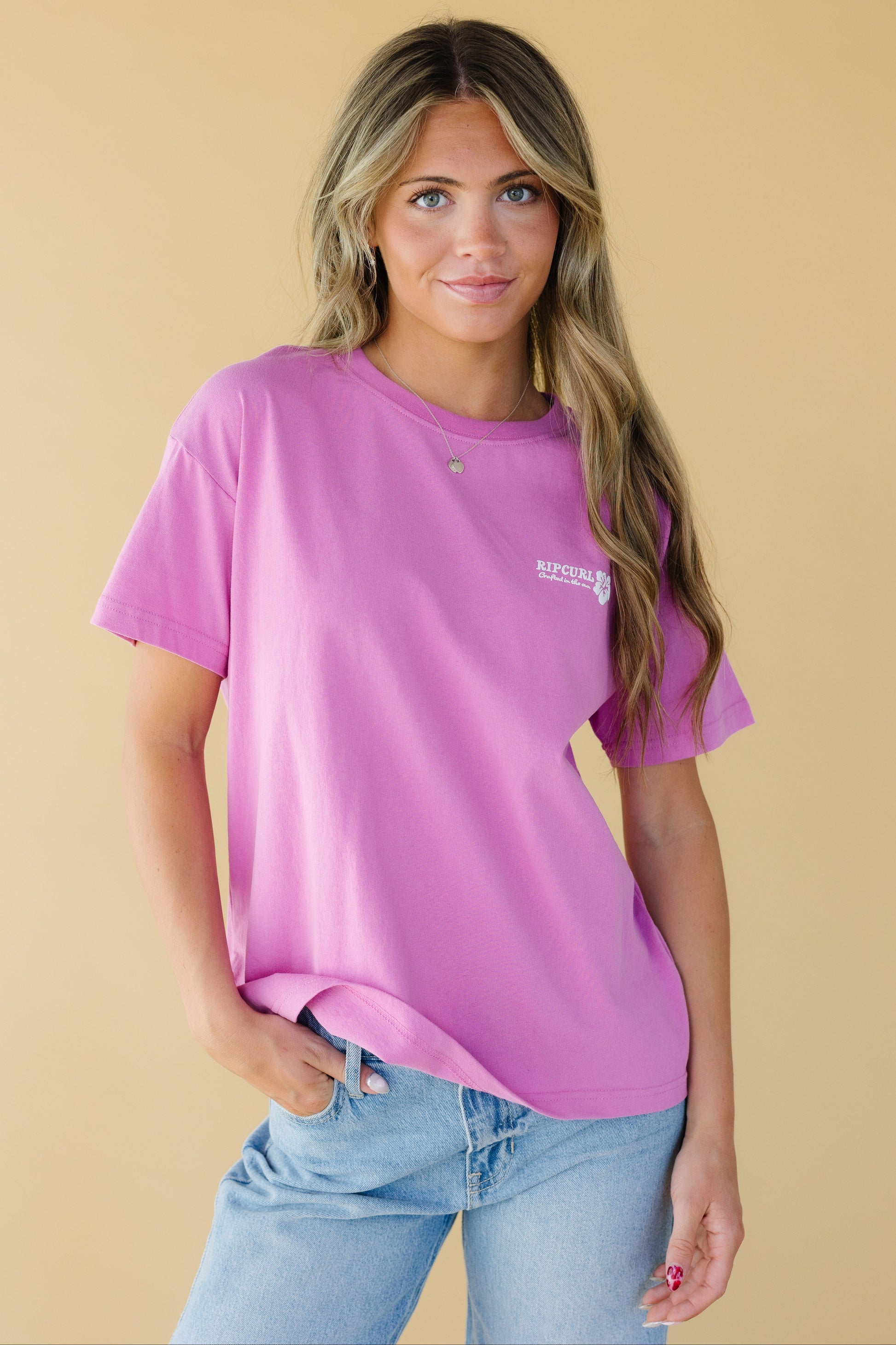 Young woman wearing a modest pink graphic tee with short sleeves and a crew neckline.