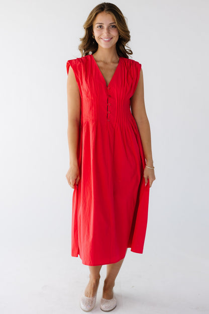 Woman wearing a red midi dress with an hour glass silhouette and a V-neckline.