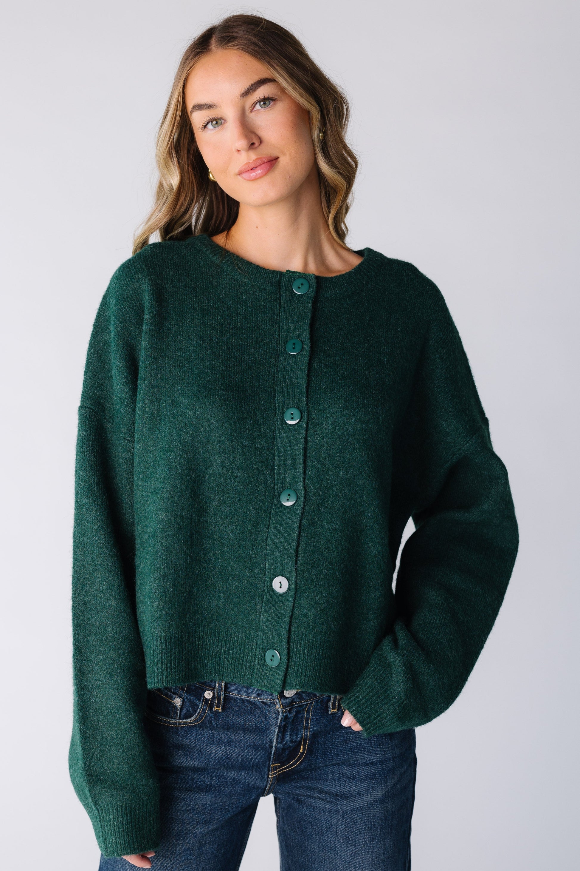 Woman wearing a dark green cardigan with long sleeves