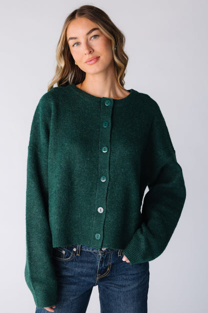 Woman wearing a dark green cardigan with long sleeves