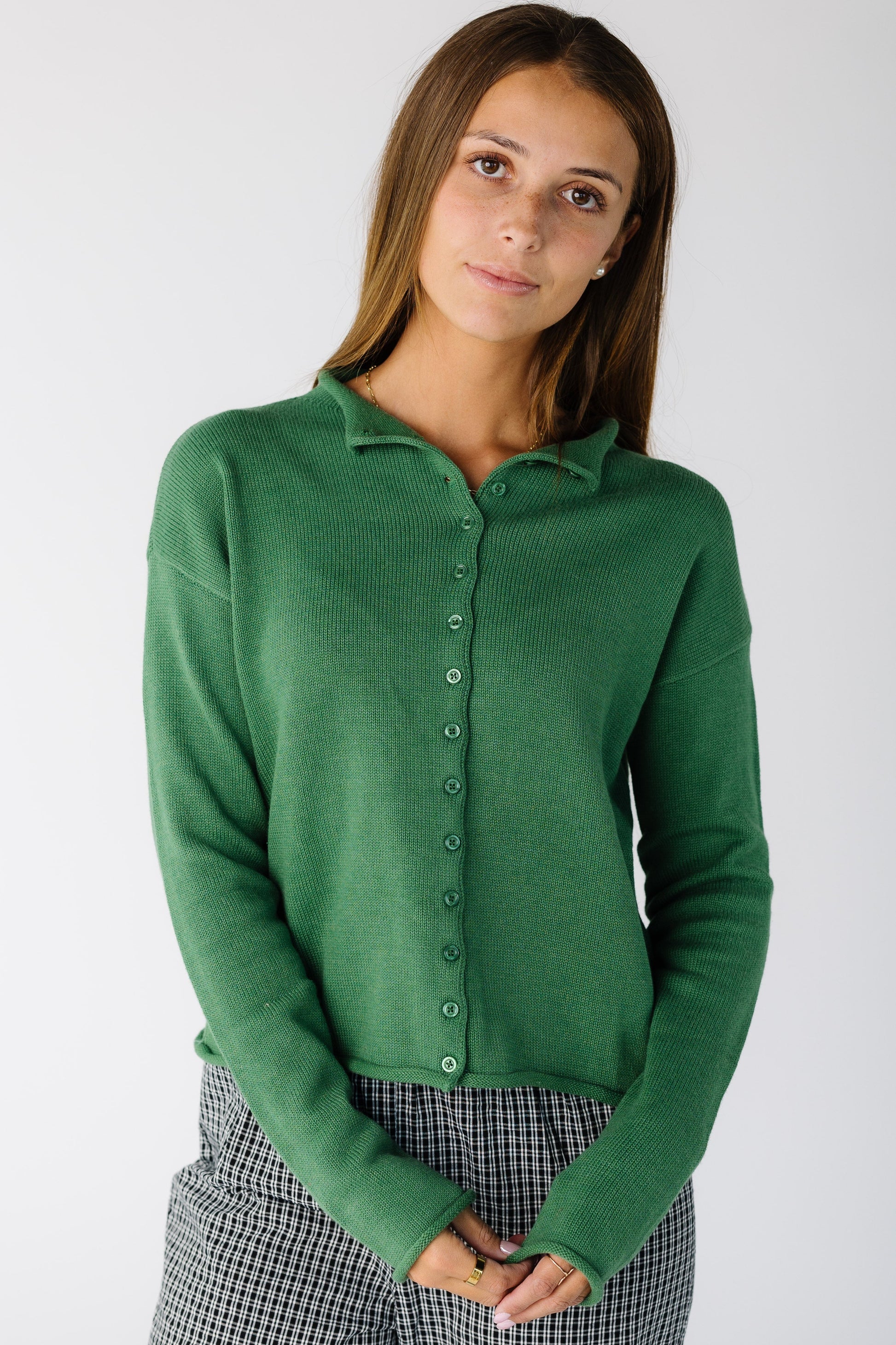 Woman wearing a long sleeve green cardigan with matching buttons