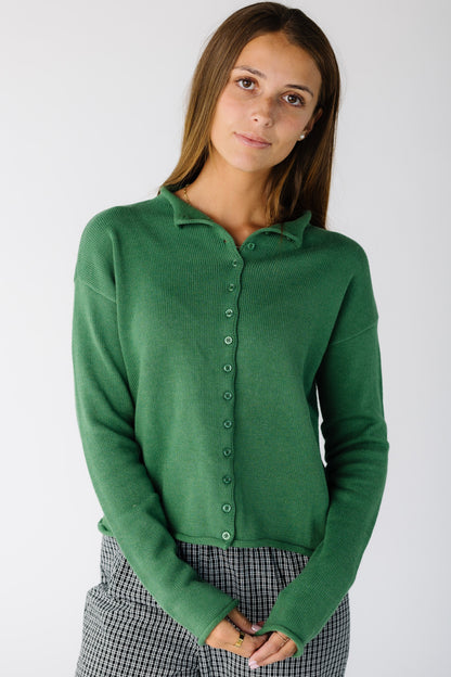 Woman wearing a long sleeve green cardigan with matching buttons