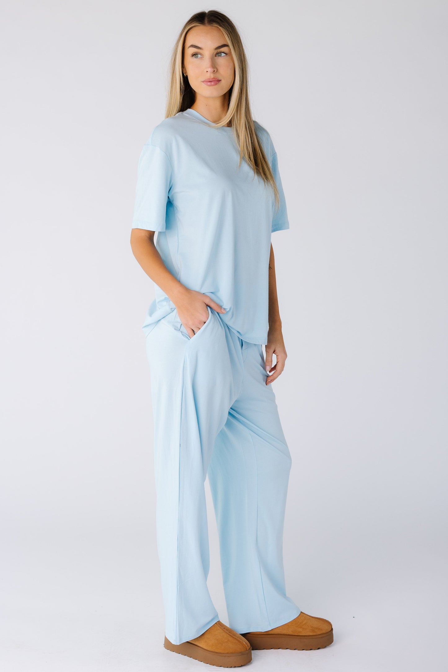Woman wearing a 2 piece light blue lounge set with pockets