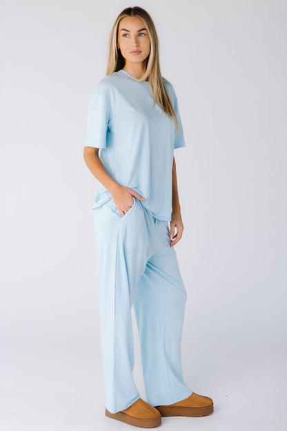 Woman wearing a 2 piece light blue lounge set with pockets