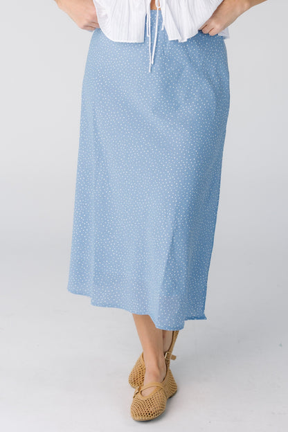 Woman wearing a light blue A-line midi skirt.