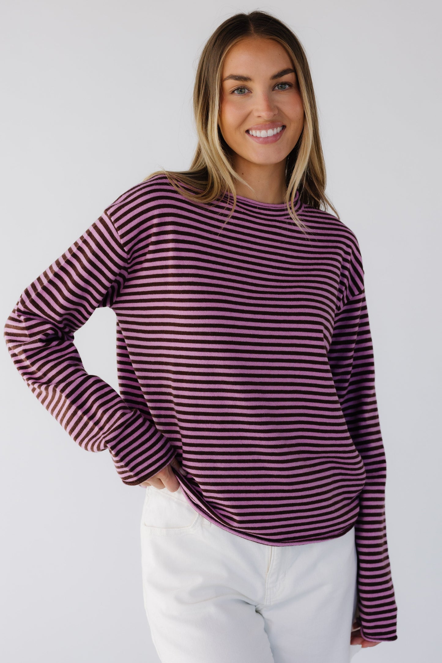 Young woman wearing a modest pink & brown stripe long sleeve knit top with a round neckline.