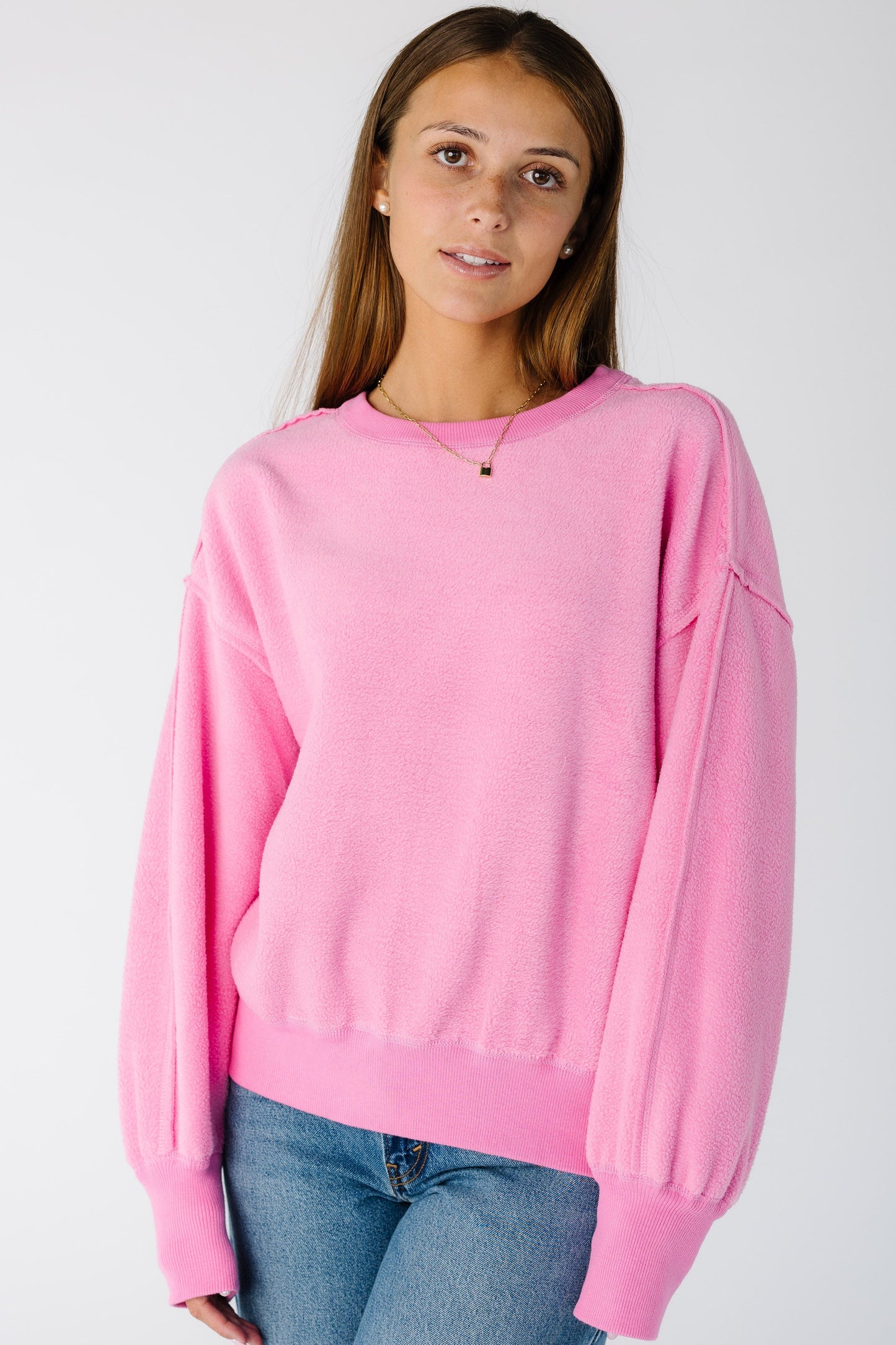 Woman wearing a pink sweatshirt-sweater with a crew neckline and long sleeves