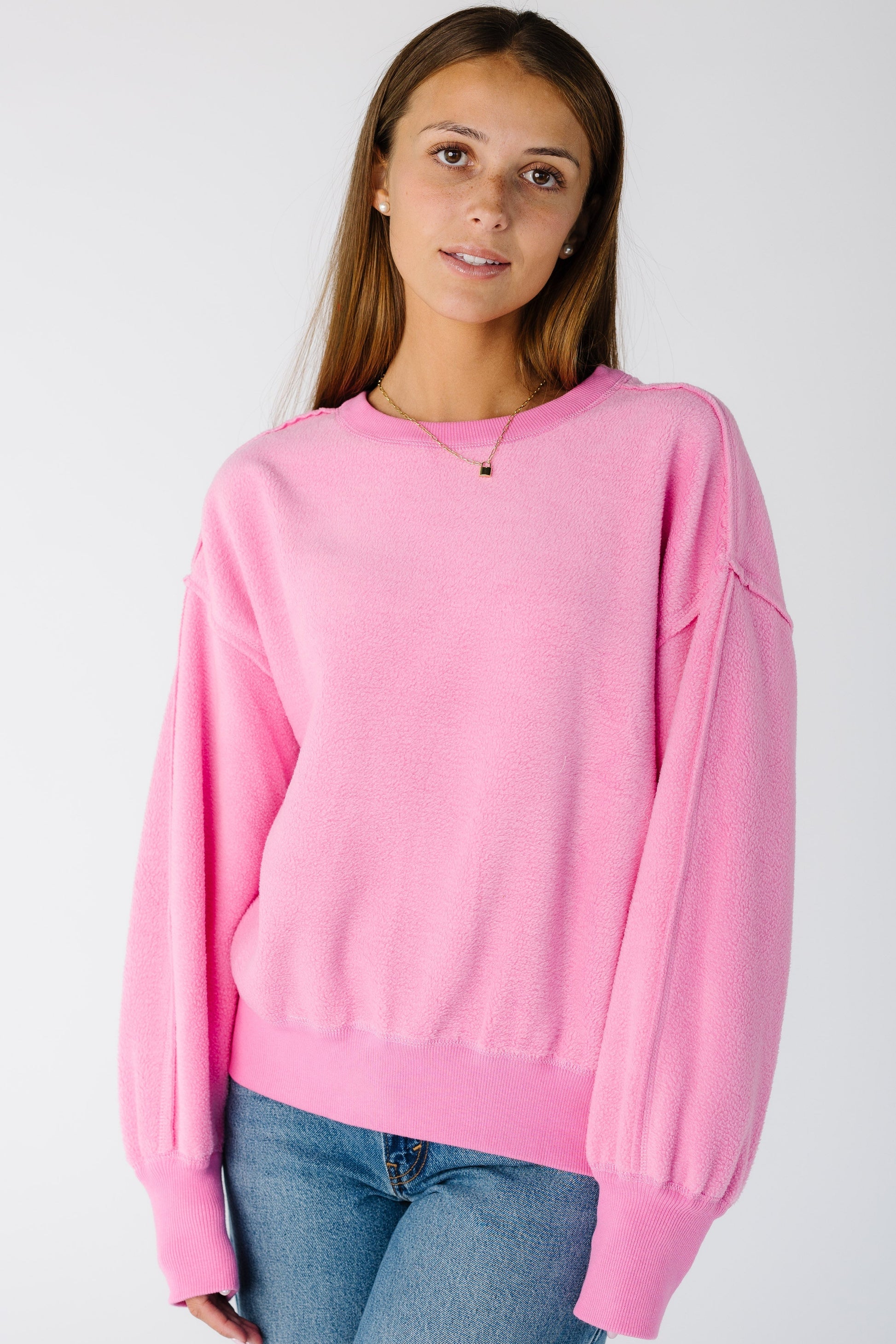 Woman wearing a pink sweatshirt-sweater with a crew neckline and long sleeves
