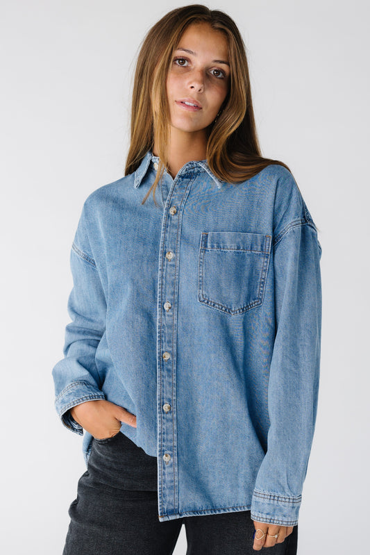 Woman wearing a medium denim button down shirt