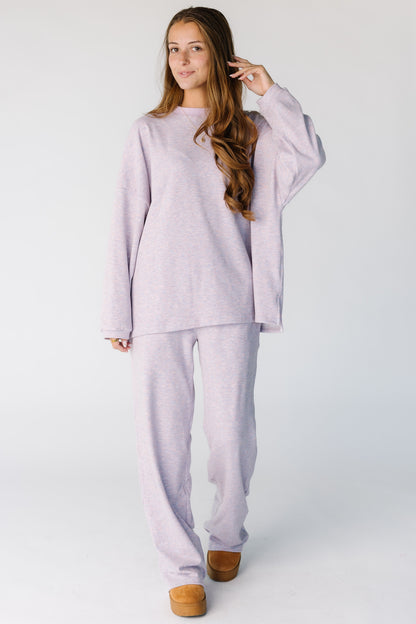 Woman wearing a modest lavender and pink 2 piece lounge set with long sleeves and long length pants.  