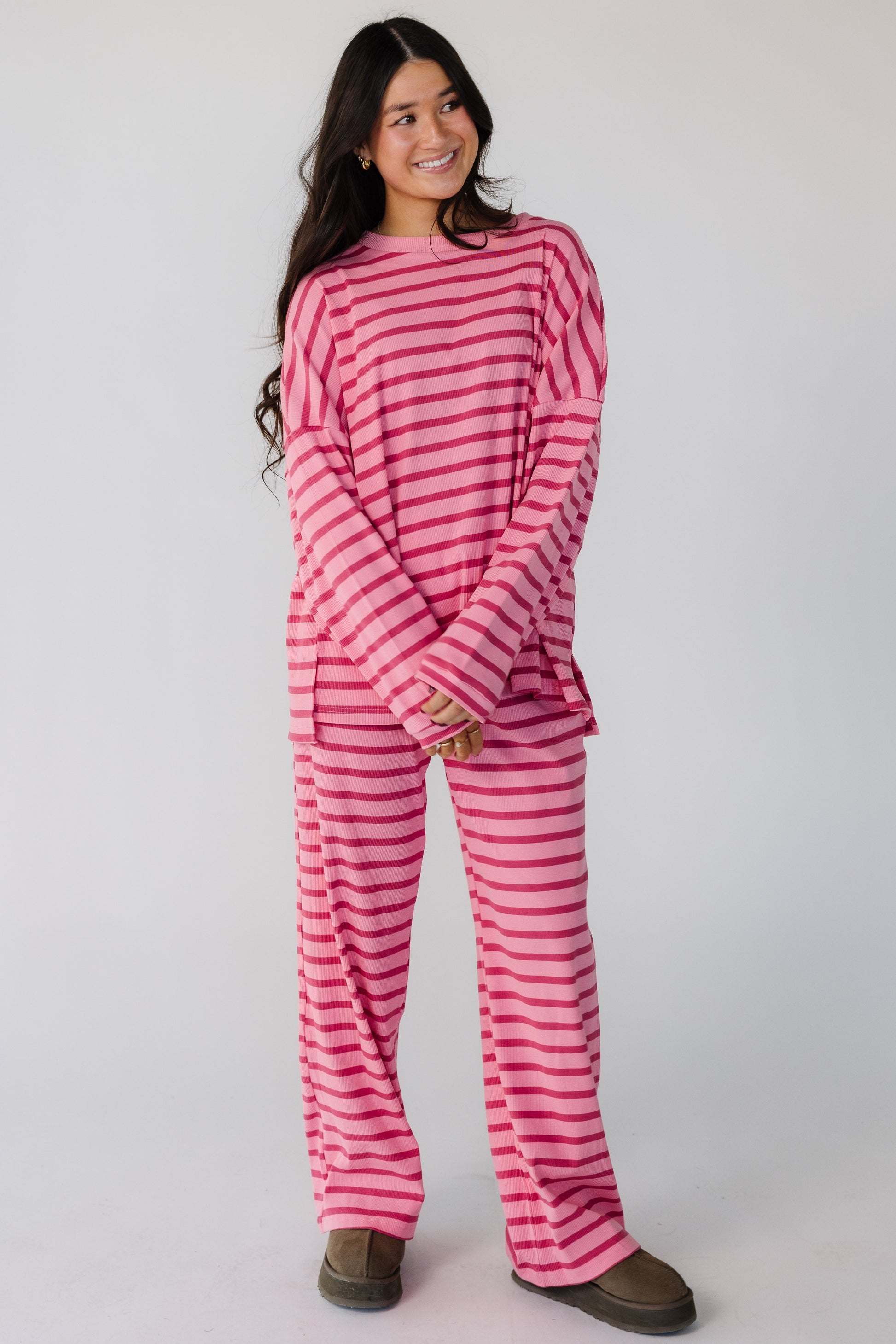 Woman wearing a pink ribbed 2 piece lounge sets with long sleeves and long length pants.