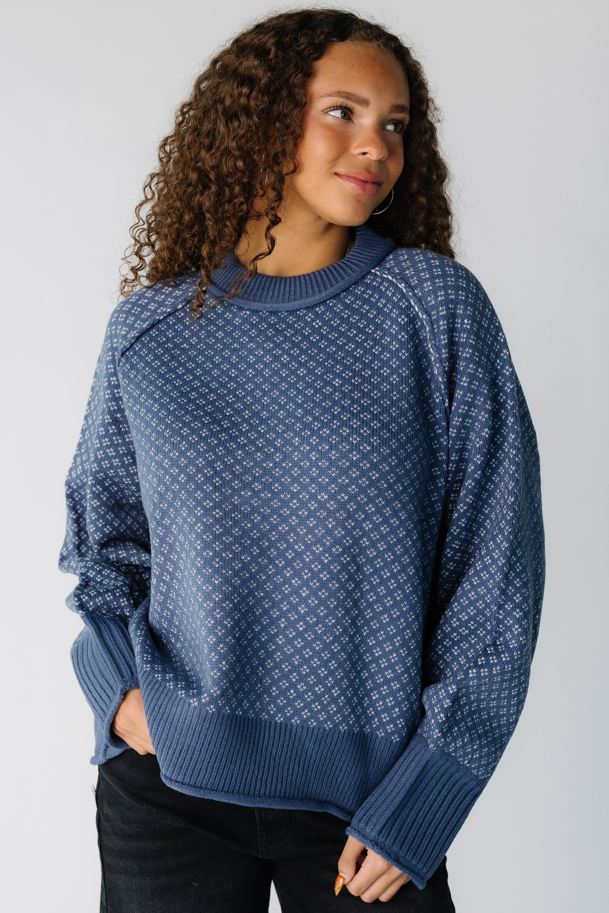 Teen girl wearing a modest blue patterned pullover sweater with long raglan sleeves and crew neckline