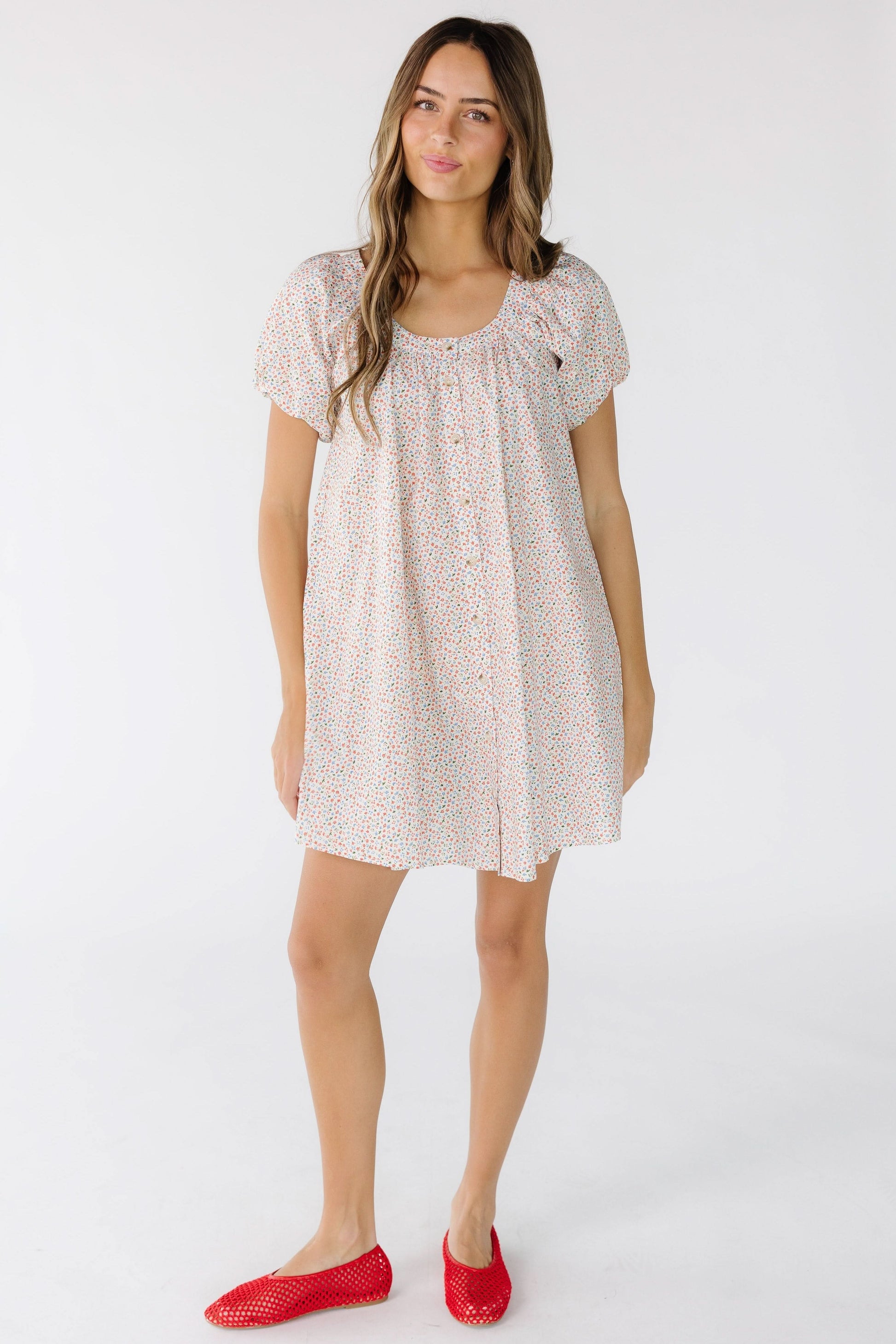 Woman wearing a modest above the knee loose fitting swing dress that buttons down the front.