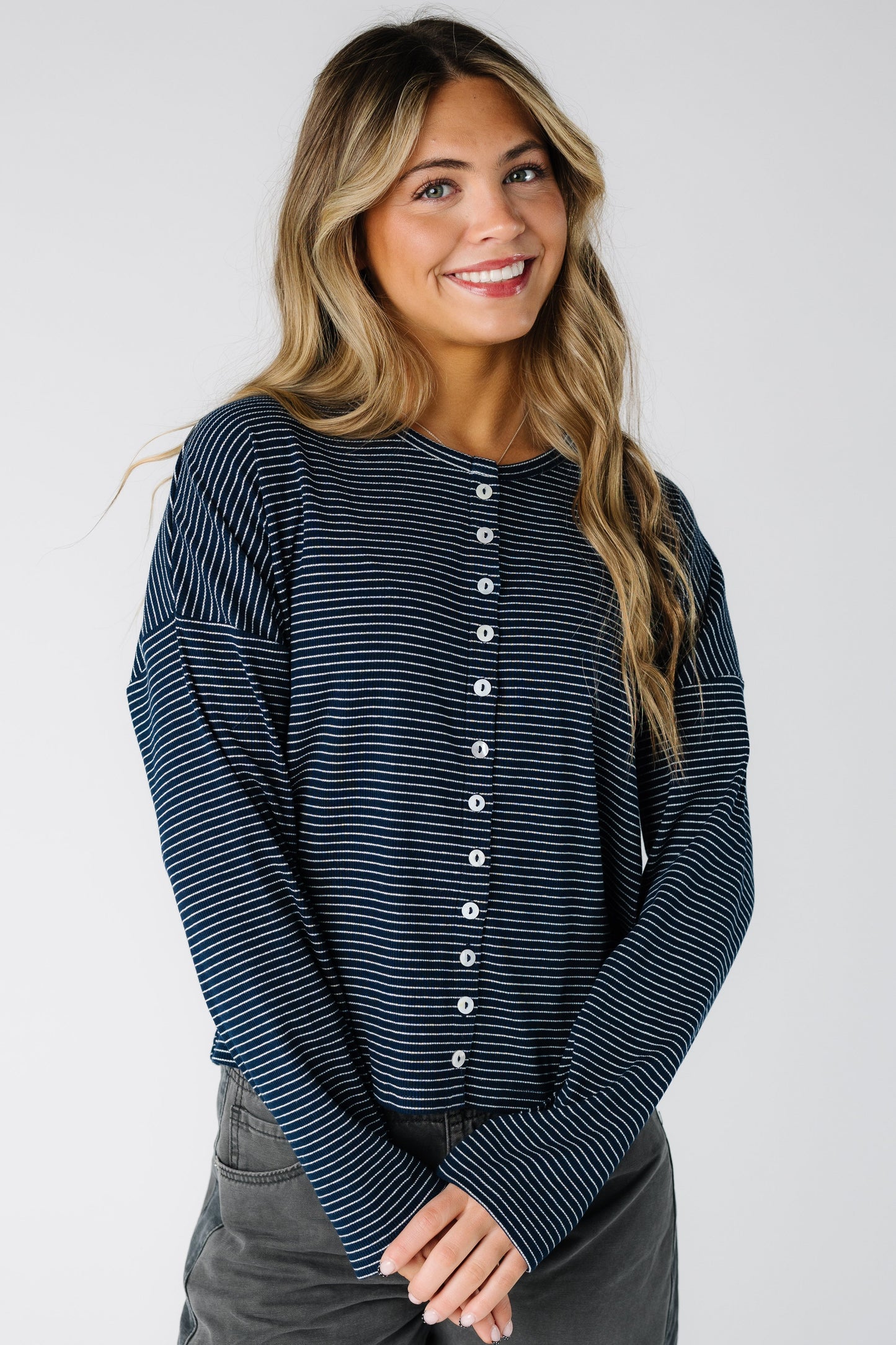 Woman wearing a modest navy pinstripe cardigan with long sleeves and round neckline