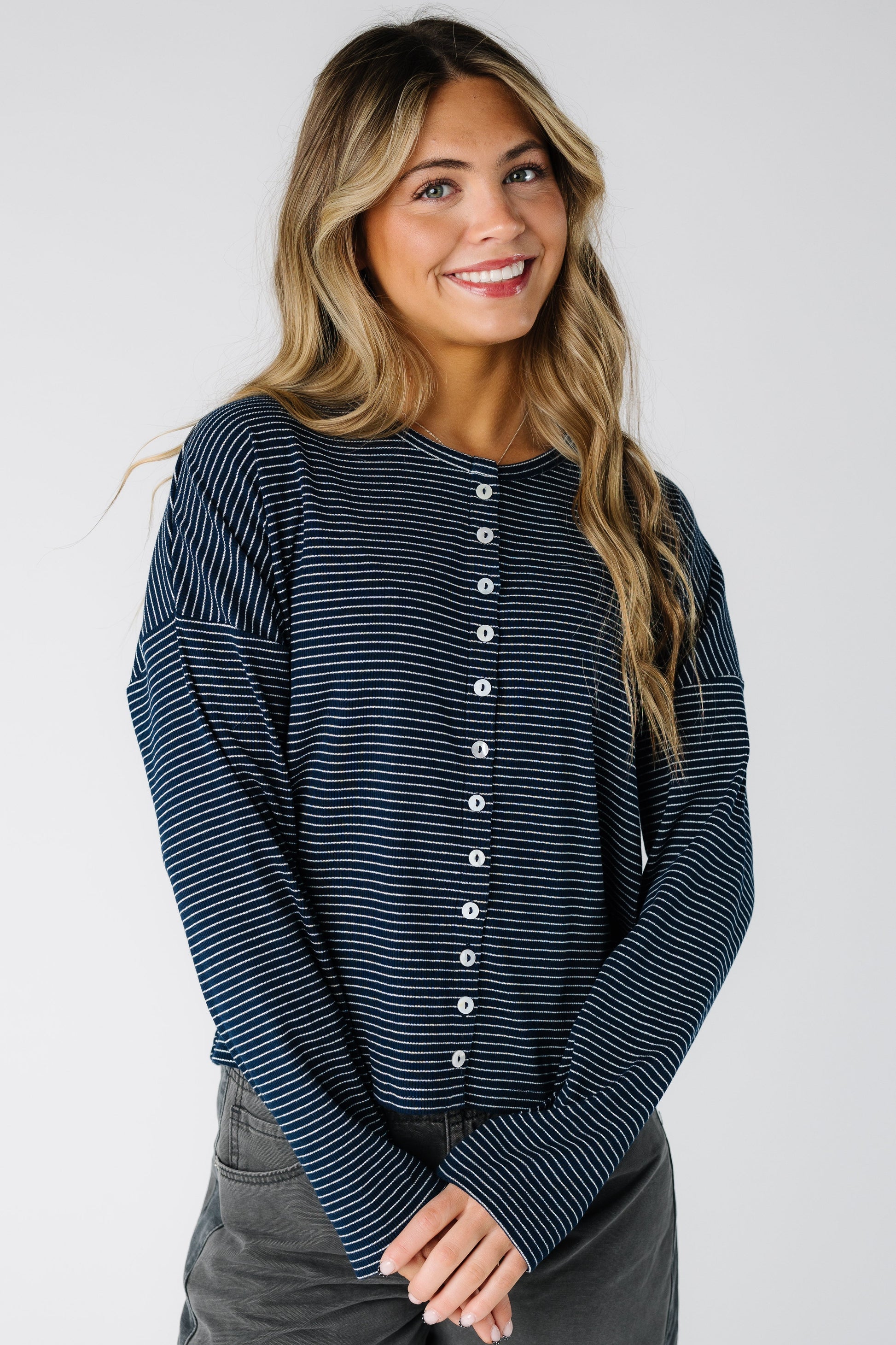 Woman wearing a modest navy pinstripe cardigan with long sleeves and round neckline