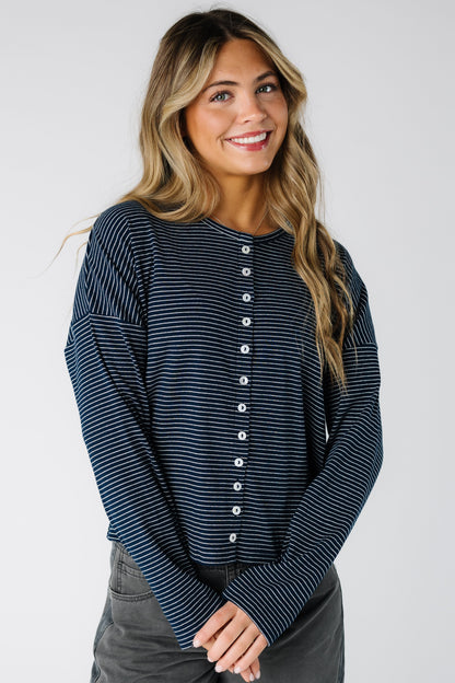 Woman wearing a modest navy pinstripe cardigan with long sleeves and round neckline