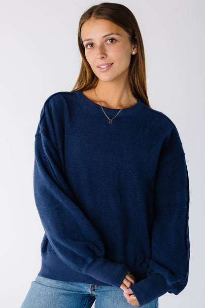Woman wearing a navy reversible sweatshirt with exposed seams