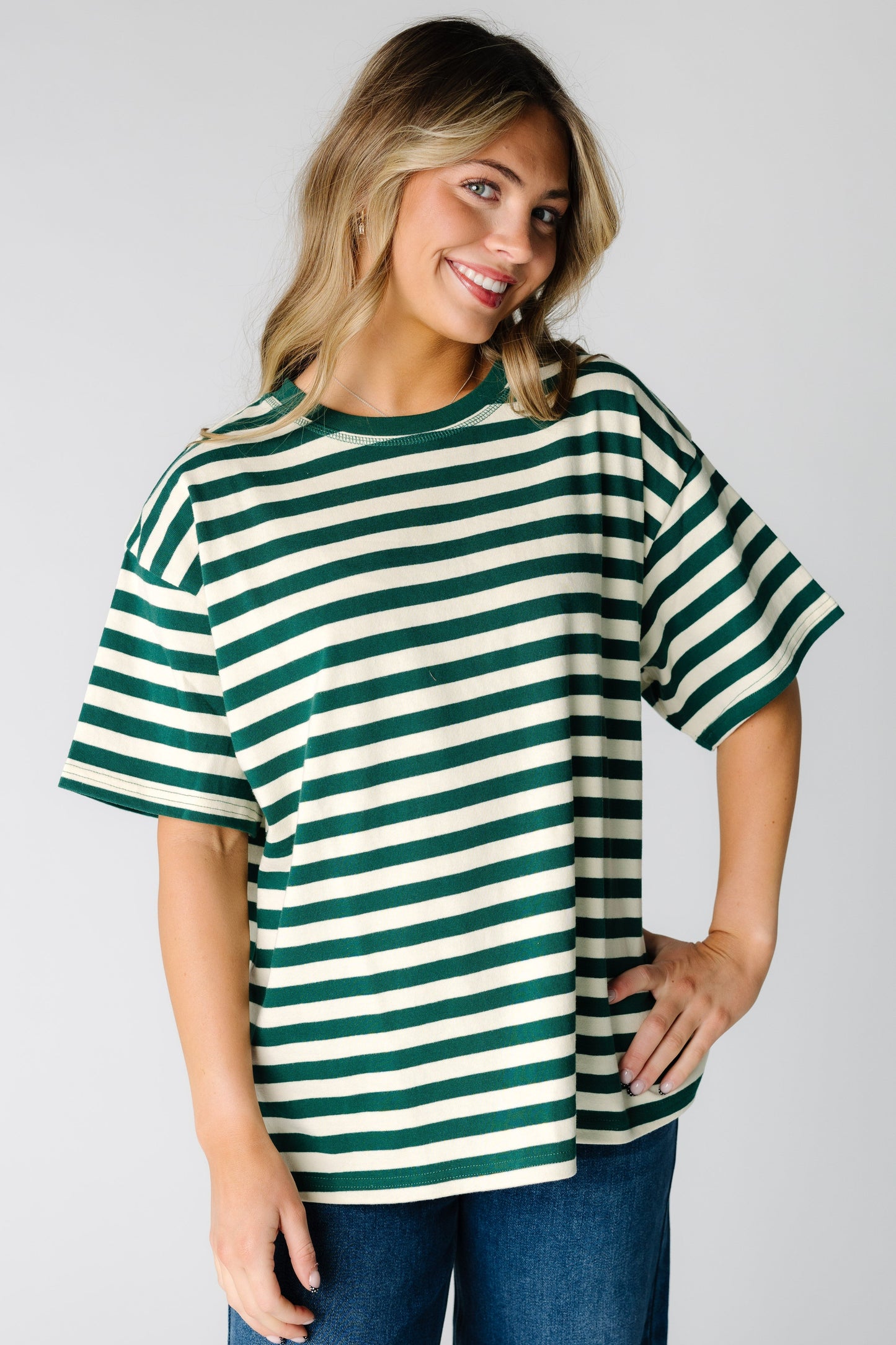 Woman wearing a loose fitting stripe tee n green