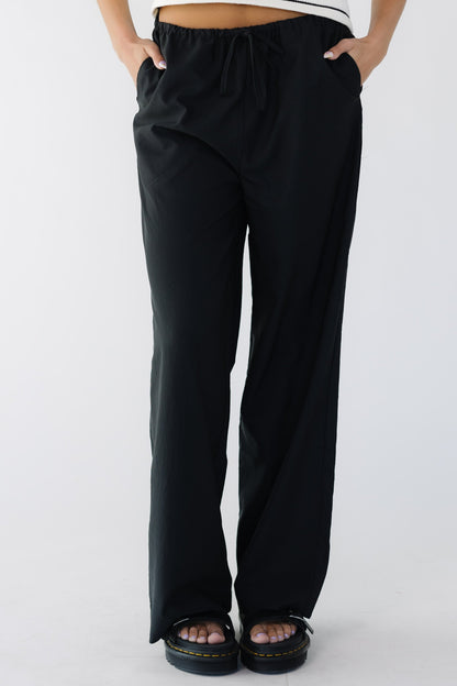 Young woman wearing lightweight black loose fitting, wide leg trouser pants.
