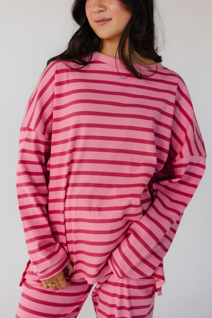 Close view of a woman wearing a pink and mauve stripe lounge set in a ribbed texture.