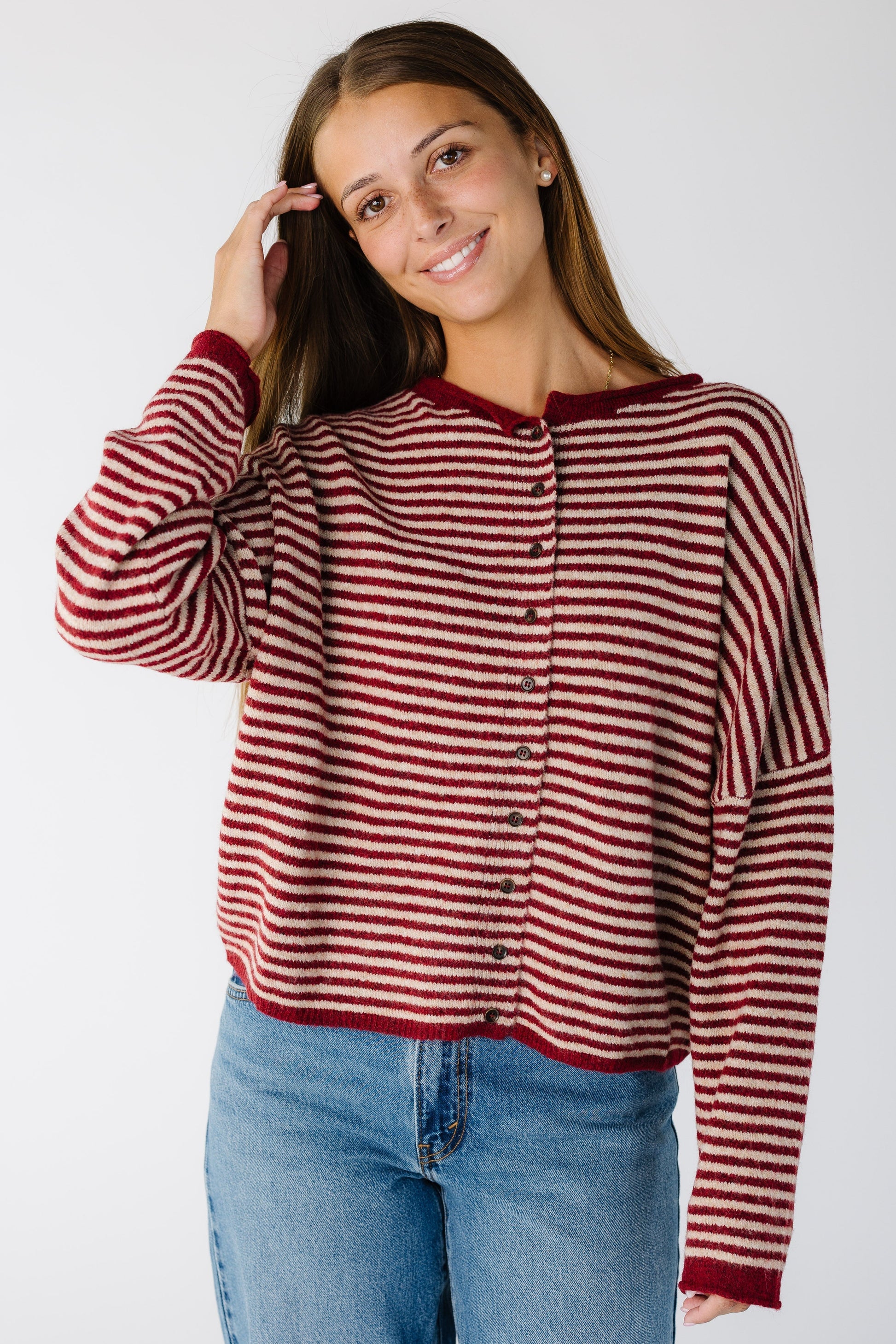 Woman wearing a loose fitting cardigan in red stripe with long sleeves