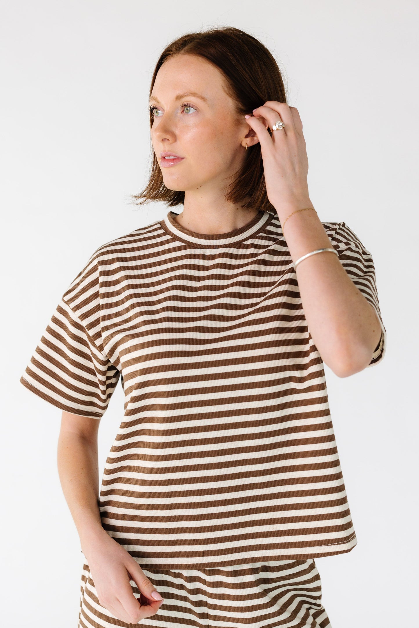 Woman wearing a modest brown and cream stripe tee with a crew neckline and  short sleeves.