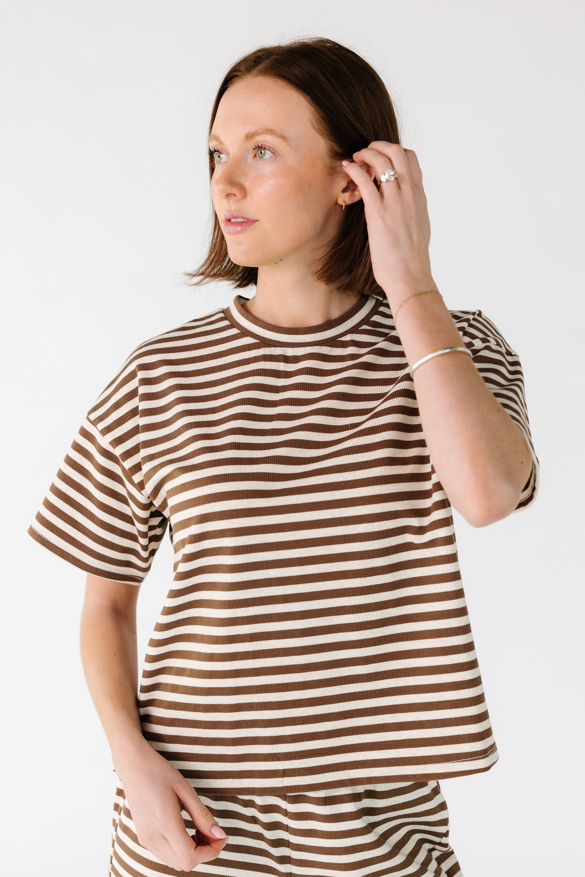 Woman wearing a modest brown and cream stripe tee with a crew neckline and  short sleeves.