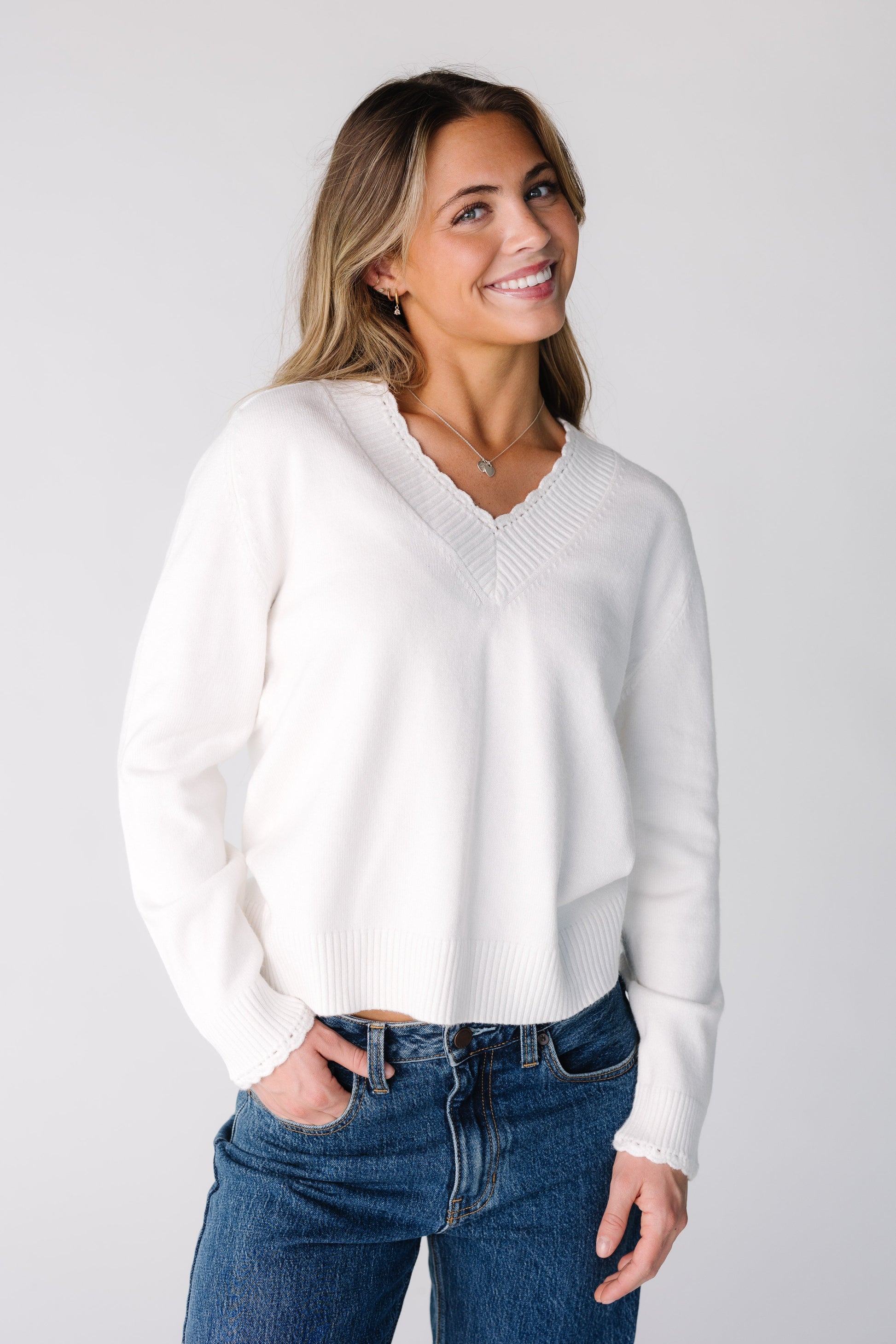 Woman wearing an off white sweater with long sleeves