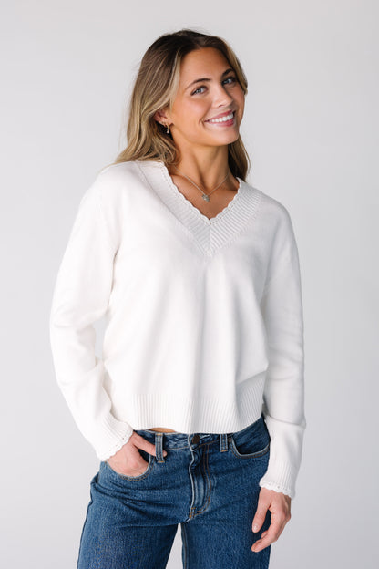 Woman wearing an off white sweater with long sleeves
