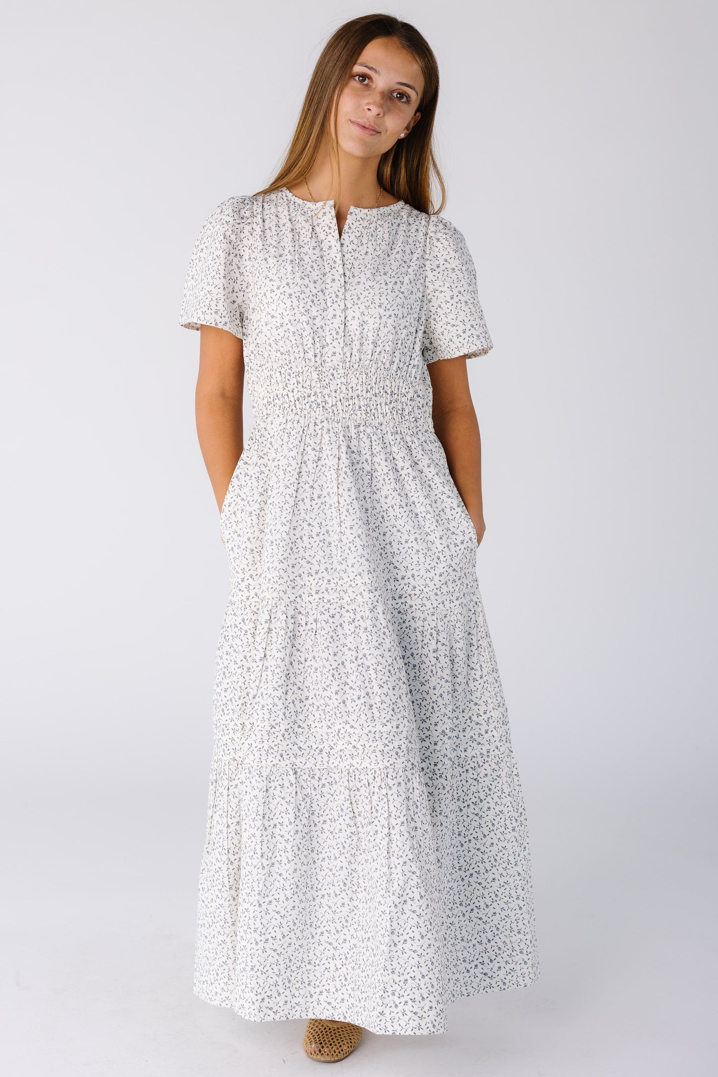 Woman wearing a modest white print midi-maxi dress with short sleeves and a V-neckline