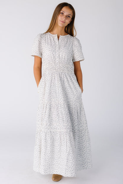 Woman wearing a modest white print midi-maxi dress with short sleeves and a V-neckline