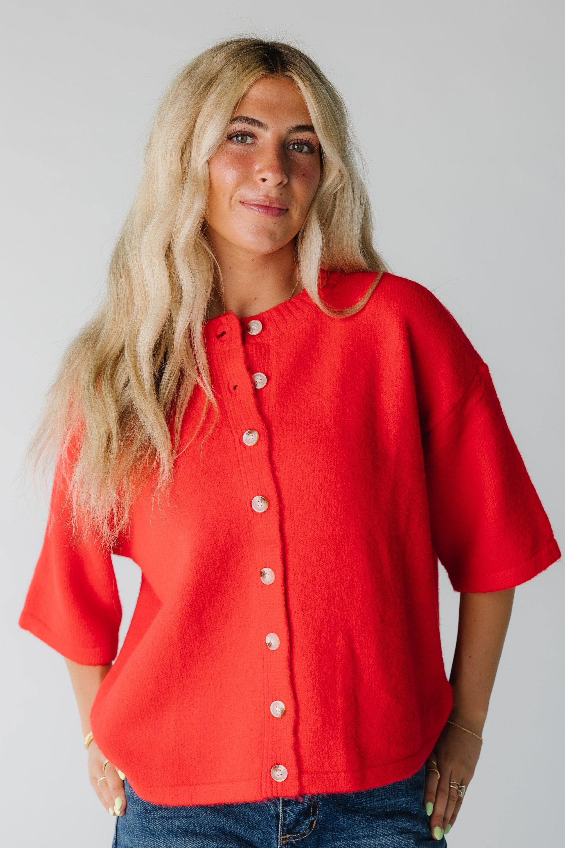 Woman wearing a red button down cardigan with half length sleeves