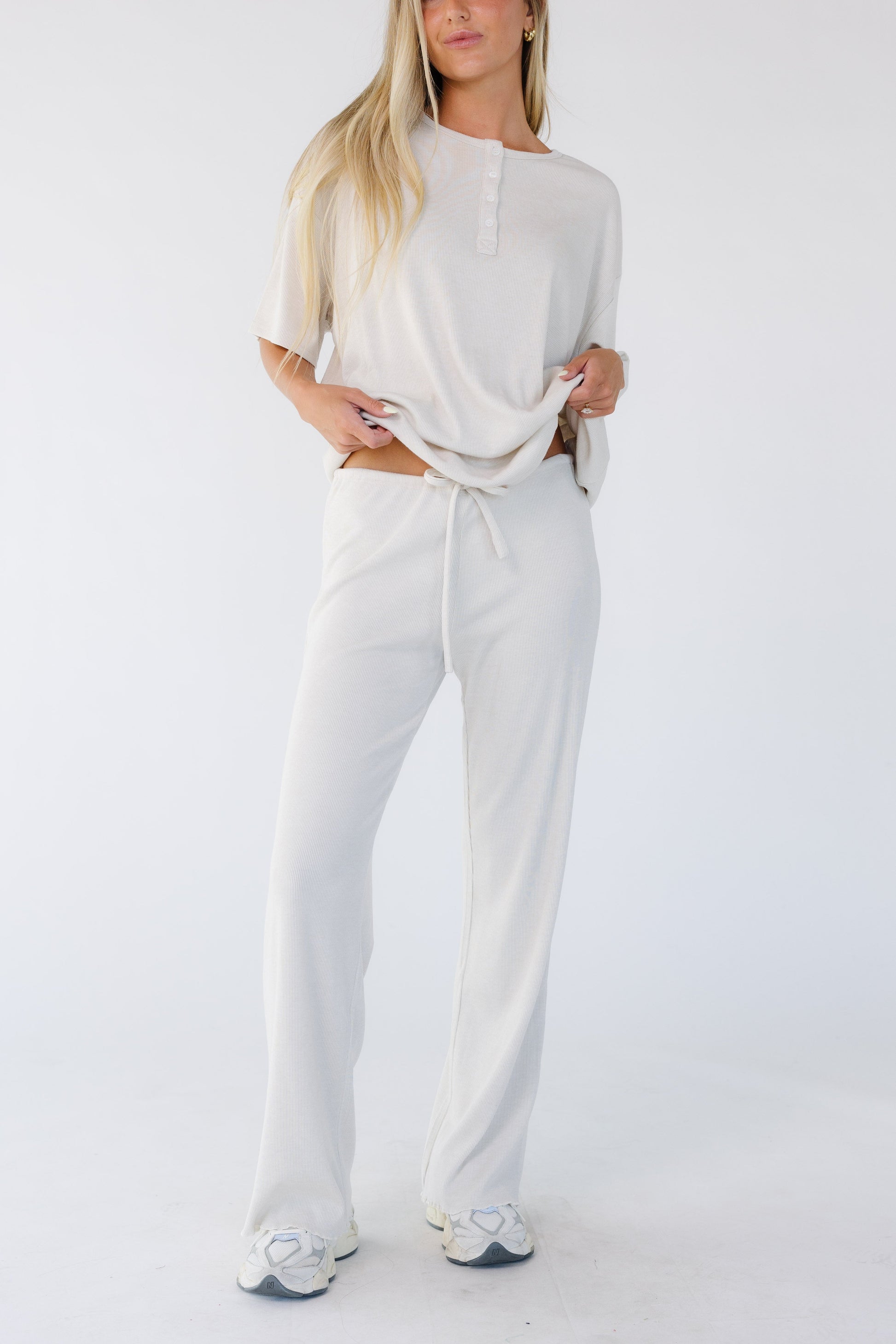 Woman wearing a pair of light beige wide cut lounge pants.