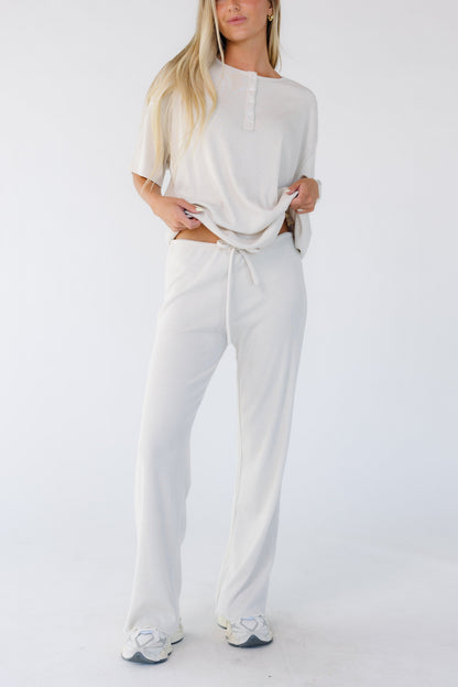 Woman wearing a pair of light beige wide cut lounge pants.