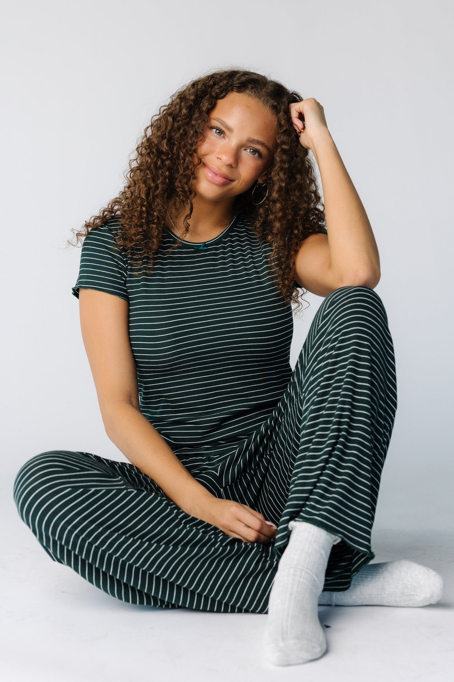 Woman seated wearing a 2 piece pajama set with short sleeves