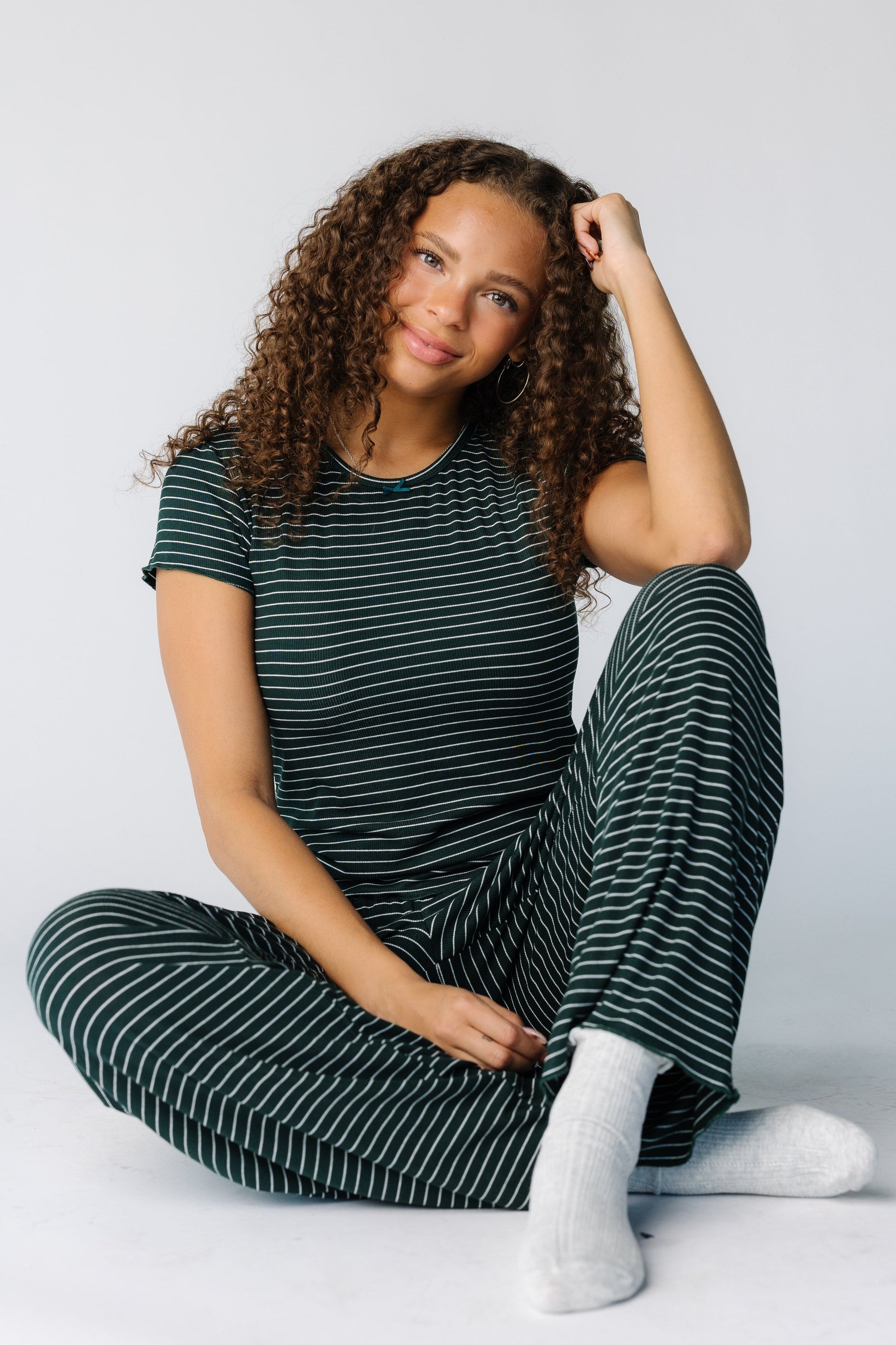 Woman seated wearing a 2 piece pajama set with short sleeves