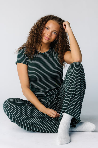 Woman seated wearing a 2 piece pajama set with short sleeves