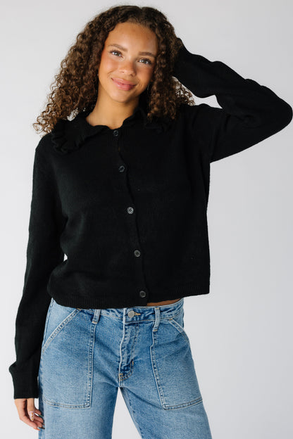 Woman wearing a black button cardigan with long sleeves