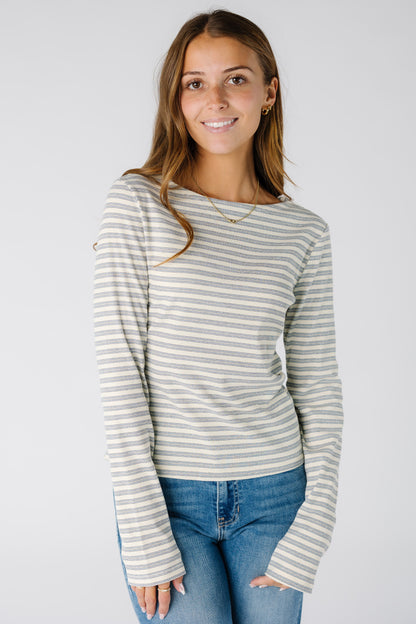 Woman wearing a blue and cream stripe ribbed top with long sleeves