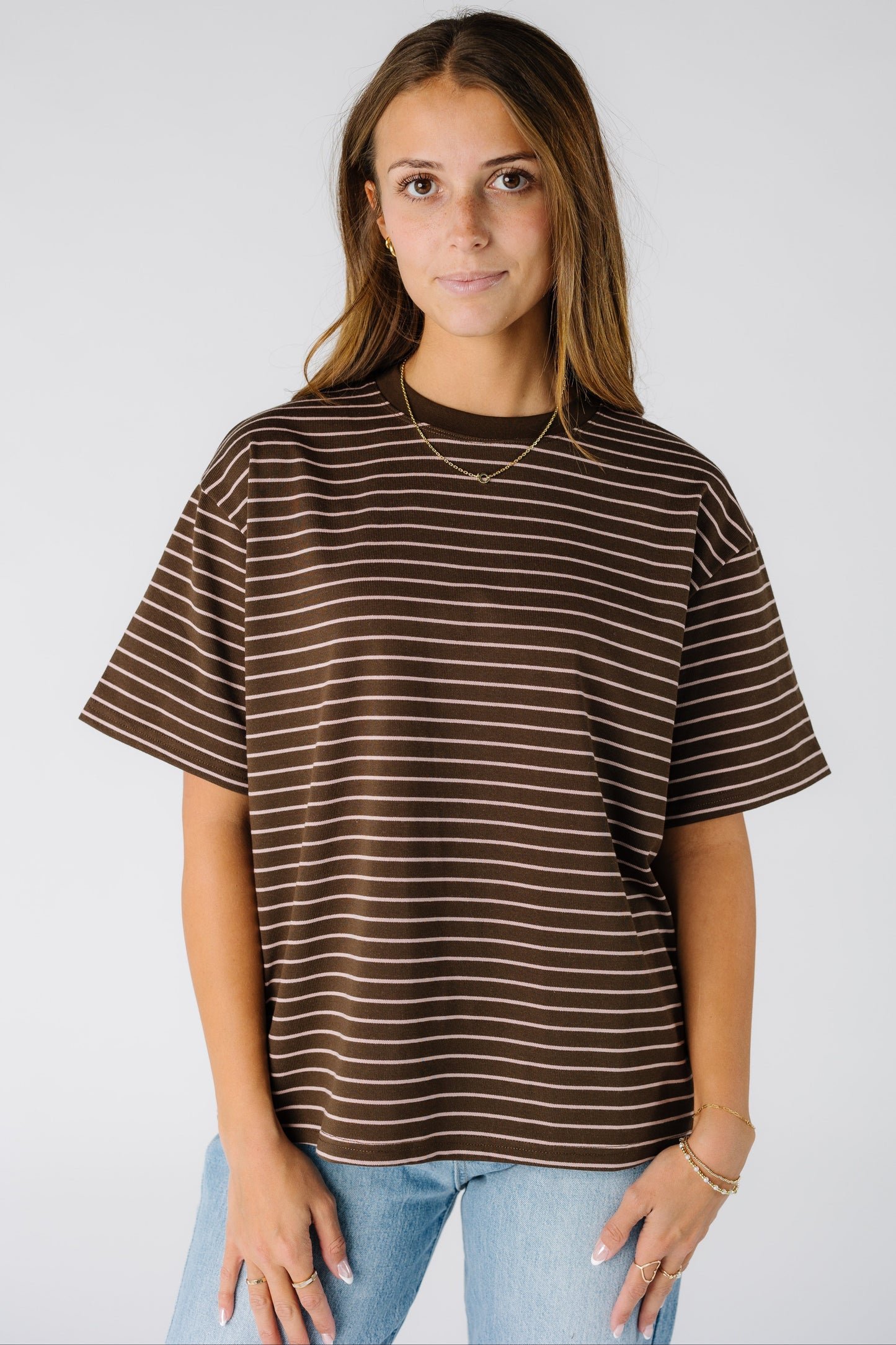 Woman wearing a brown stripe top with short sleeves and a crew neckline