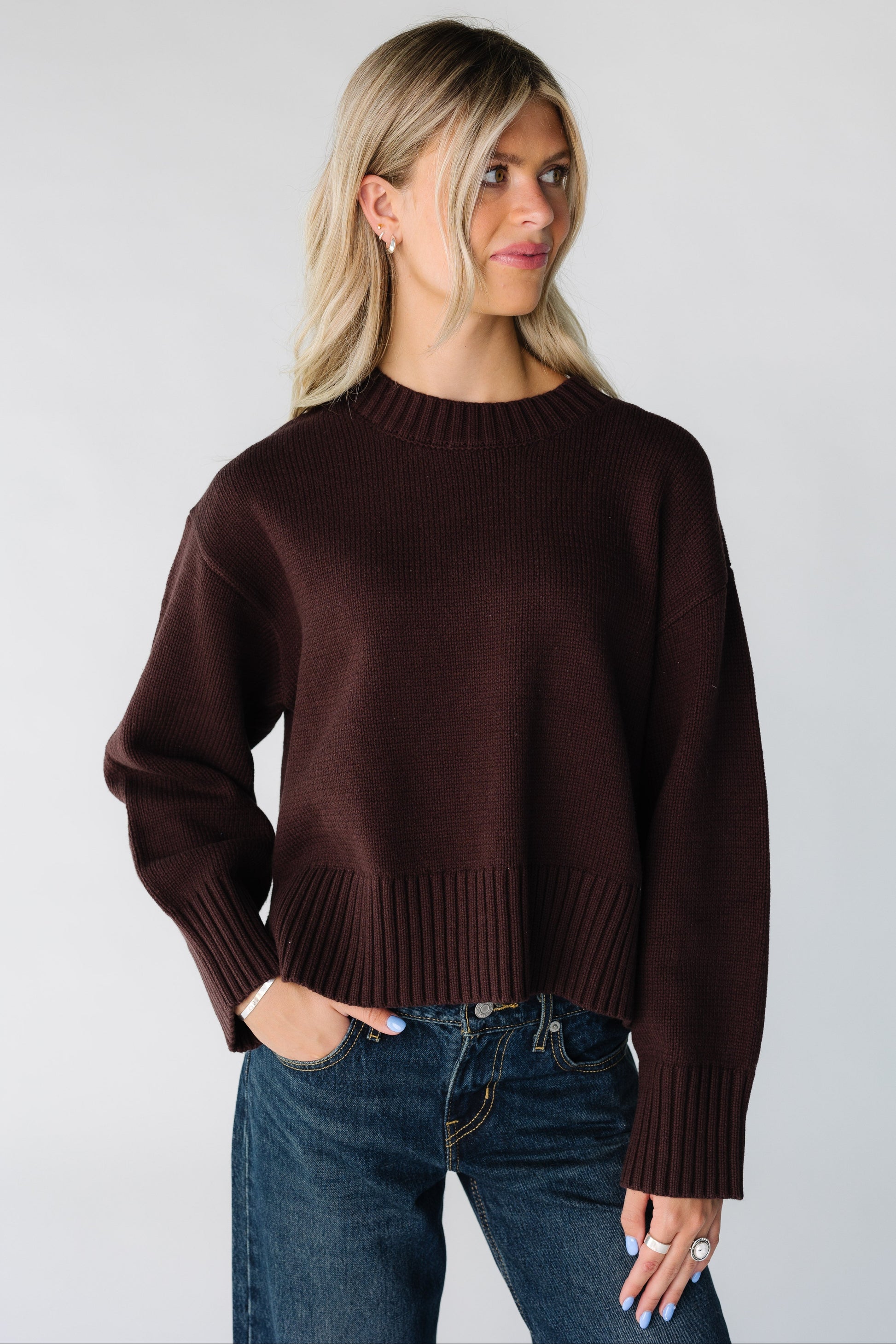 Woman wearing a brown loose fitting sweater with long sleeves