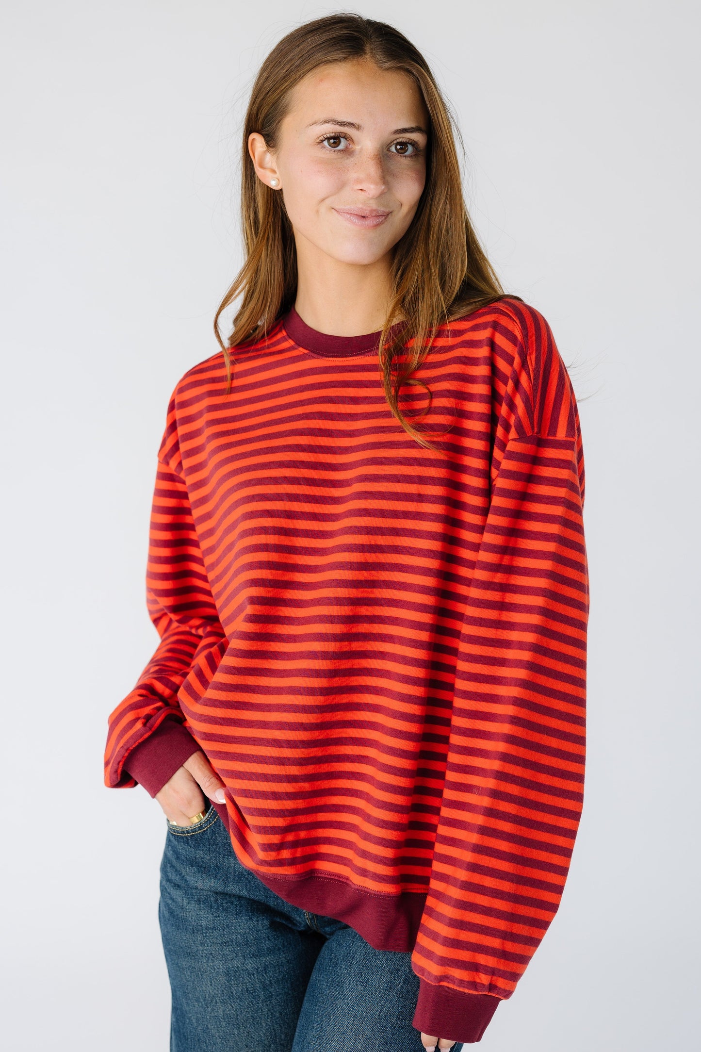 Woman wearing a modest  loose fitting sweatshirt in a burgundy stripe 