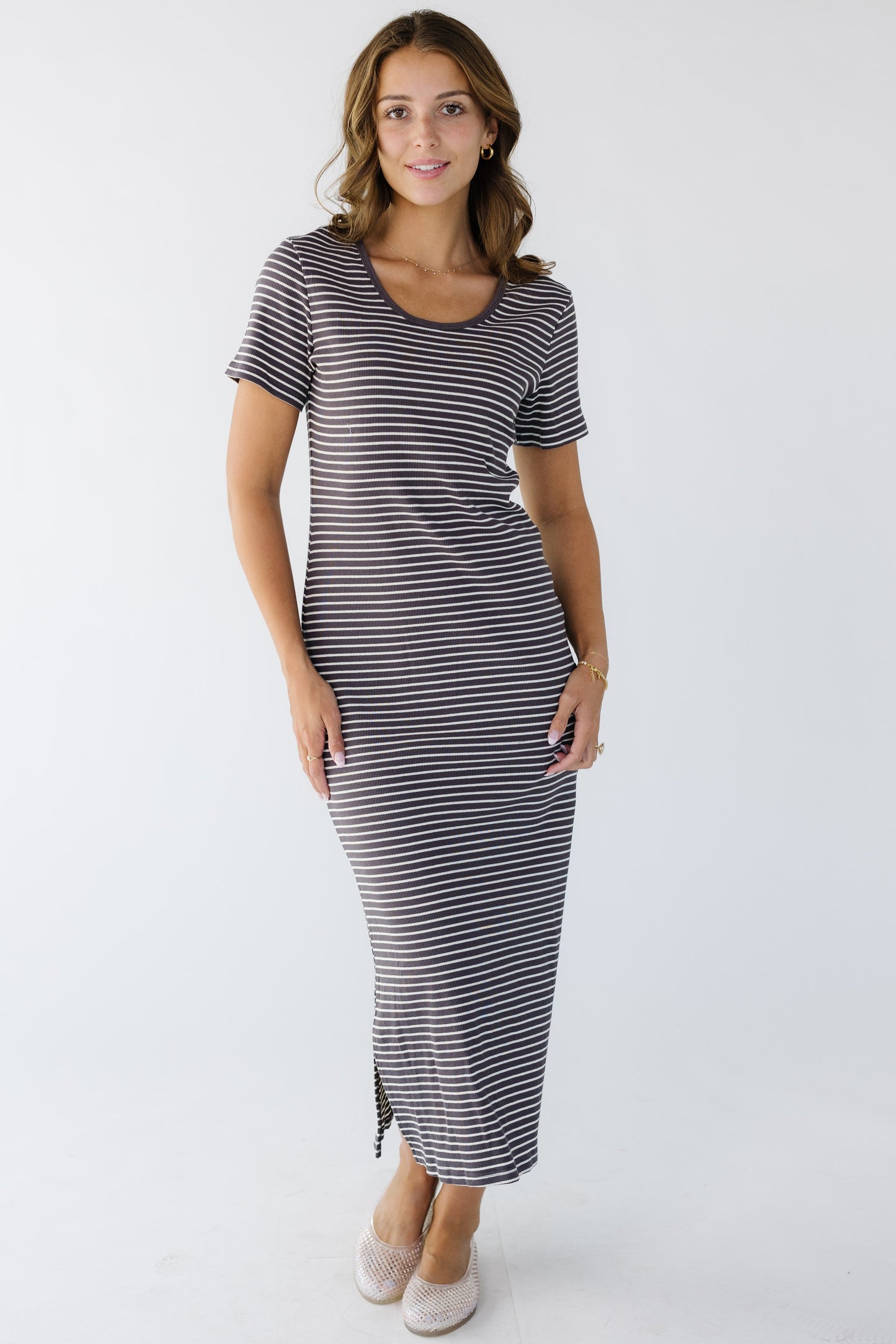 Young woman wearing a narrow brown and white stripe close fitting knit midi dress.