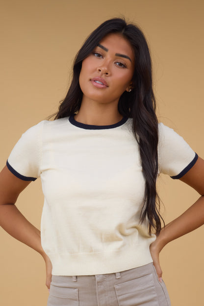 Young woman wearing a modest short sleeve top with a contrasting neckline and contrasting cuffs.