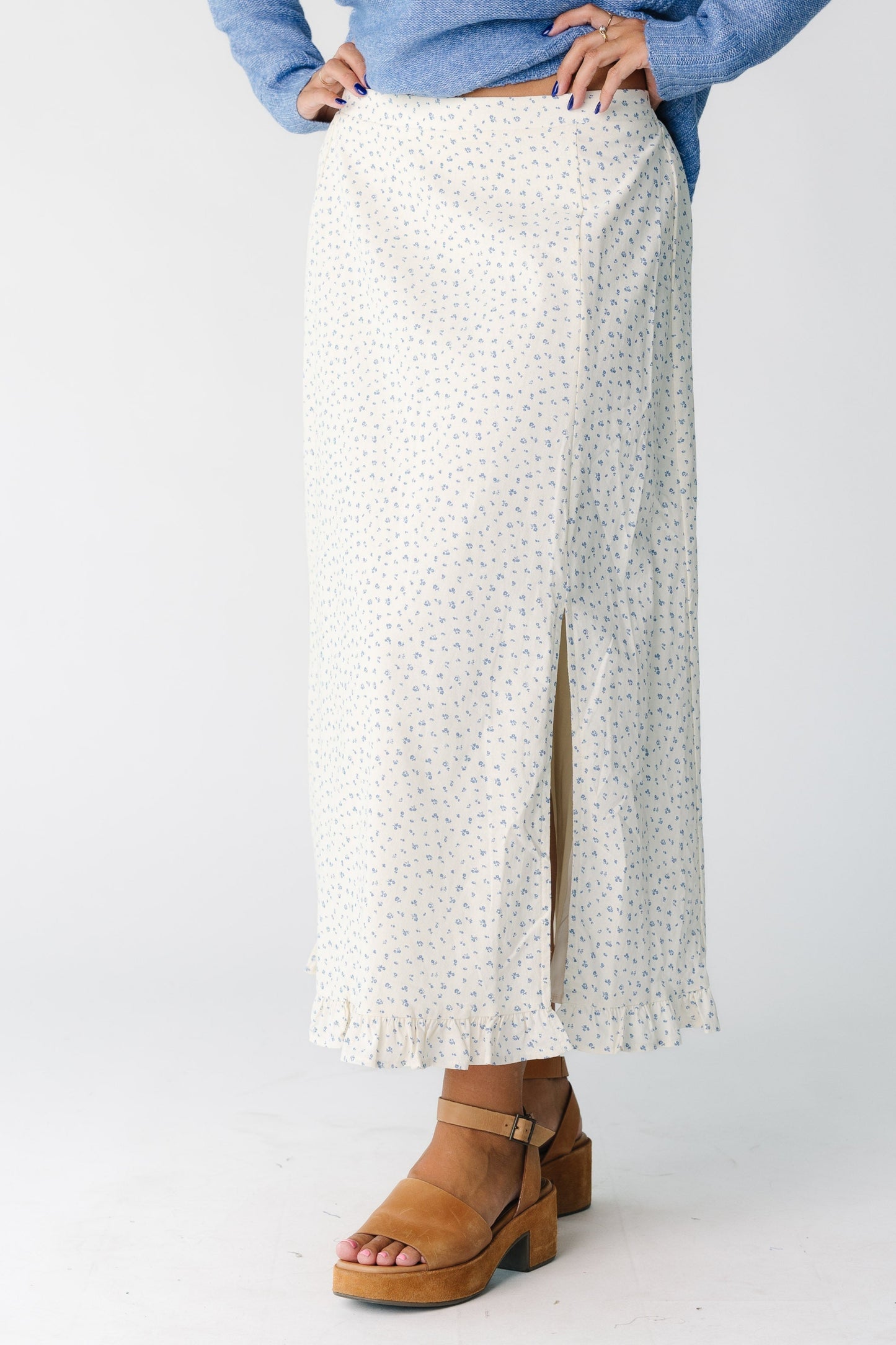 Woman wearing a cream floral skirt with slit