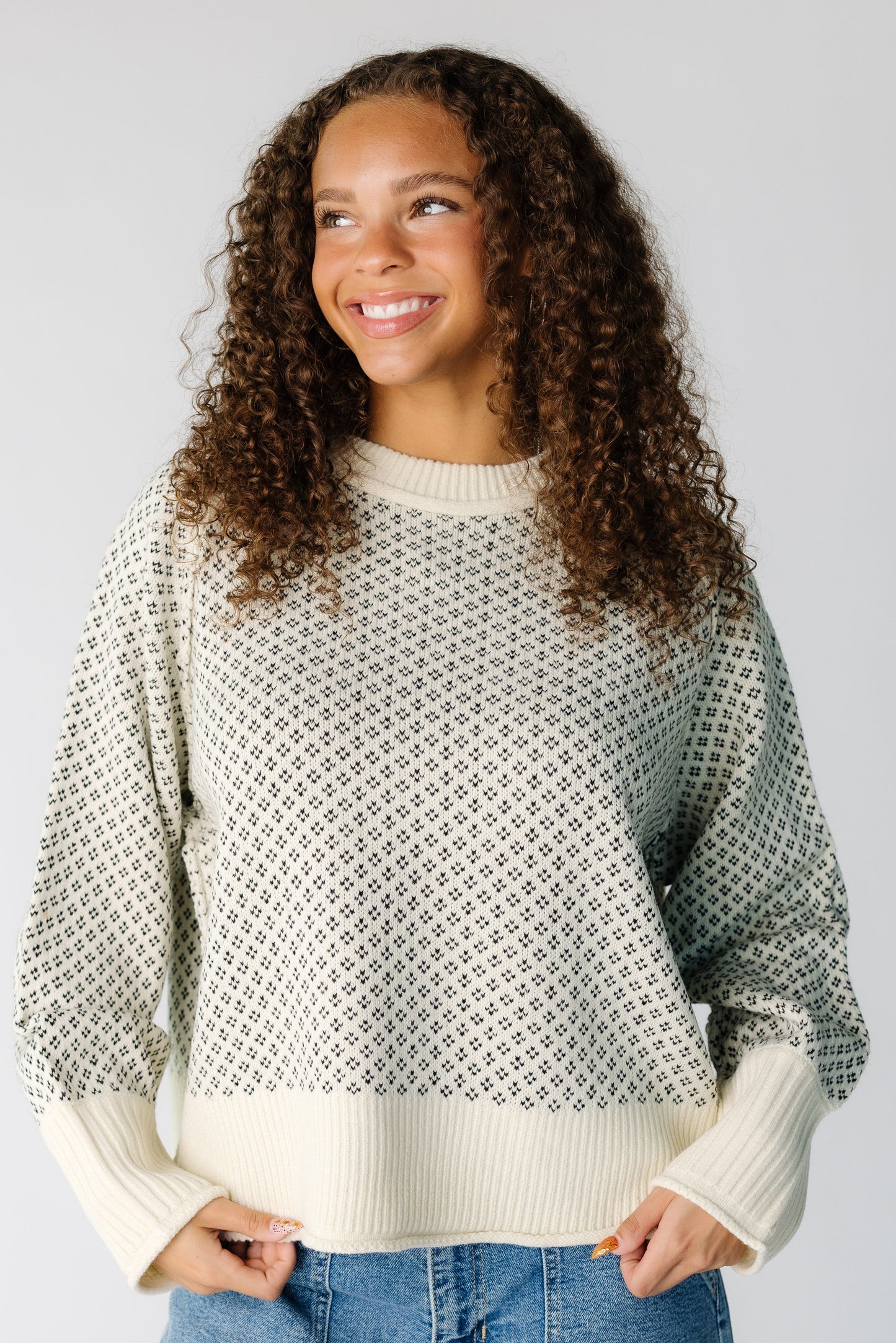 Teen girl wearing a modest cream & black pullover with long sleeves and a crew neckline