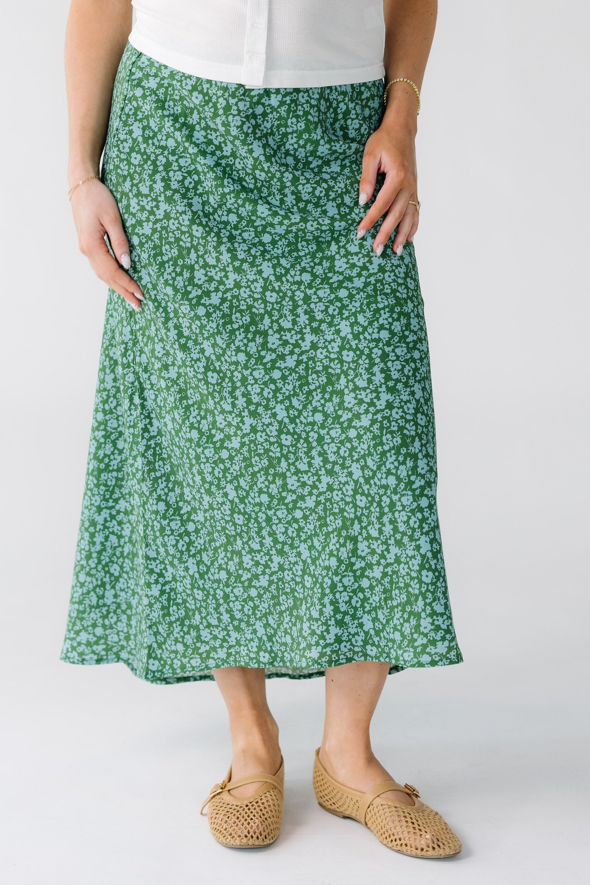 Woman wearing a green and light blue A-line skirt with a high-low hemline.