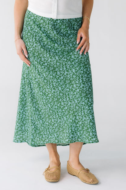 Woman wearing a green and light blue A-line skirt with a high-low hemline.